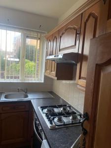 a kitchen with a stove top oven next to a sink at Spacious 2 Bedroom Apartment in Zone 2 LONDON in London