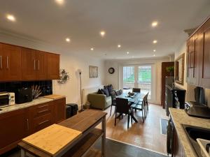 a kitchen and living room with a table and a couch at 4 bed house 10 min walk to Tube in London