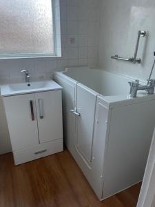 een witte badkamer met een bad en een wastafel bij Spacious 2 Bedroom Apartment in Zone 2 LONDON in Londen