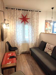 a living room with a couch and a star on the window at Apartament Trawertynowy Chrobrego 15 Sopot in Sopot