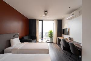 Habitación de hotel con 2 camas y escritorio en Linn Hotel Bac Giang en Bắc Giang