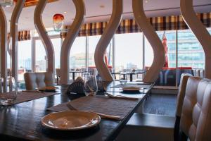 فندق سويس-بل هوتيل سيف البحرين في المنامة: غرفة طعام مع طاولة وكراسي ونوافذ