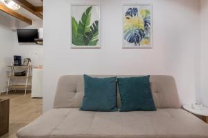 een bank in een woonkamer met twee blauwe kussens bij Mariviky design apartment in Chania