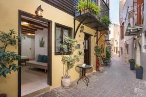 een steegje met potplanten en een tafel bij Mariviky design apartment in Chania