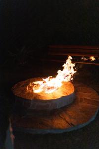 una hoguera con llamas sobre una mesa de madera en Chalés Recanto da Mantiqueira en Gonçalves