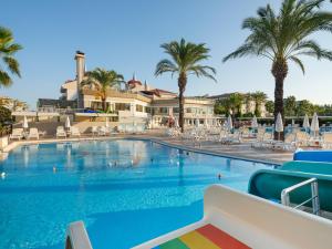una grande piscina con palme e sedie di Aydinbey Famous Resort - Ultra All Inclusive a Belek Altre 42 foto