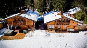 a large wooden house with snow on top of it at Le Chalet des Grands Montets 2 in Chamonix-Mont-Blanc