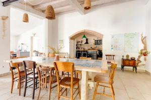 uma cozinha com uma grande mesa de madeira e cadeiras em Domu Prexada B&B em Maracalagonis