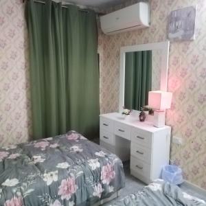 1 dormitorio con cama, tocador y espejo en العين الهيلي مصباح ب 6, en Al Ain