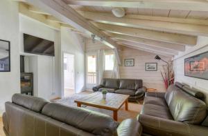 a living room with a leather couch and a table at Le Chalet des Grands Montets 2 in Chamonix-Mont-Blanc