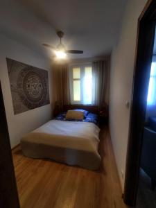 a bedroom with a bed and a ceiling fan at Apartament Trawertynowy Chrobrego 15 Sopot in Sopot