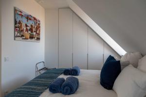 a bedroom with a bed with blue towels on it at Stunning duplex - 3 bedroom - 2 sunny terrasses in Knokke-Heist