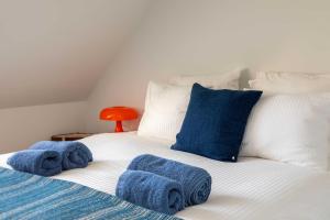- un lit avec des serviettes bleues assises au-dessus dans l'établissement Stunning duplex - 3 bedroom - 2 sunny terrasses, à Knokke-Heist