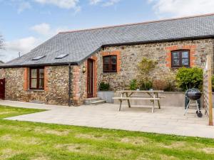 a stone cottage with a picnic table in front of it at 1 Bed in Holsworthy GBLUE in Sutcombe