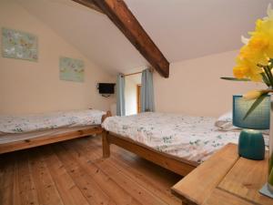 1 dormitorio con 2 camas y un jarrón de flores amarillas en 3 Bed in Bude HARVE, en Kilkhampton