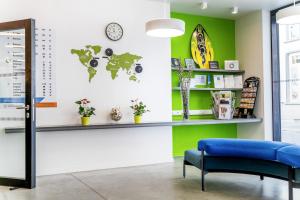 une salle d'attente avec un banc bleu et un mur vert dans l'établissement De Ploate Hostel, à Ostende