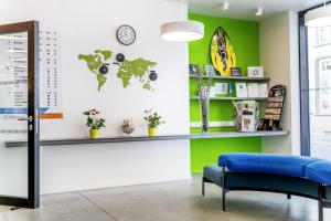 a waiting room with a blue bench and a green wall at De Ploate Hostel in Ostend