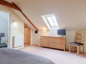 una camera con letto e TV su un comò di 2 bed property in Axminster BLOLO ad Axminster