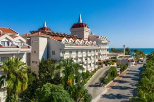 um resort com palmeiras em frente em Aydinbey Famous Resort em Belek