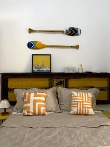 a bed with a wooden headboard and a baseball bat on the wall at Pousada na Praia Maricá in Maricá