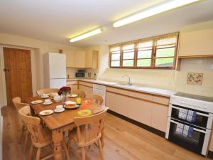 a kitchen with a wooden table with chairs and a dining room at 3 Bed in Wembury KEEPI in Wembury