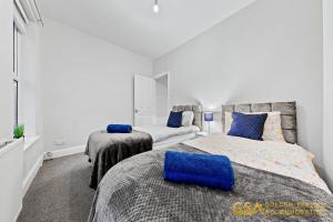 - une chambre avec deux lits et un canapé dans l'établissement 3 Bed Home in Forest Gate - Waltham Forest, à Londres