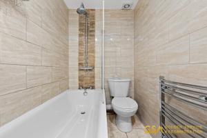 La salle de bains est pourvue de toilettes, d'une baignoire et de toilettes. dans l'établissement 3 Bed Home in Forest Gate - Waltham Forest, à Londres