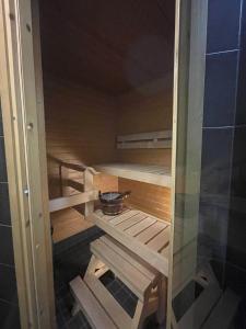 uma sauna com degraus de madeira e uma tigela em Pearl Apartment em Rovaniemi