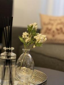 um vaso de vidro com flores sobre uma mesa em Pearl Apartment em Rovaniemi