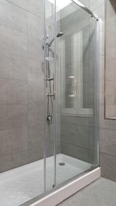 una doccia con una porta in vetro in un bagno di Hotel Meublè Santa Chiara Suite a Napoli