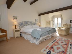 1 dormitorio con 1 cama grande y 1 silla en 1 Bed in Frome St Quintin MANJE, en Frome Saint Quinton