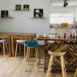 斯瓦科普蒙德的住宿－3 BDR Villa , unique in Swakopmund，厨房设有带凳子的酒吧以及带葡萄酒瓶的桌子。