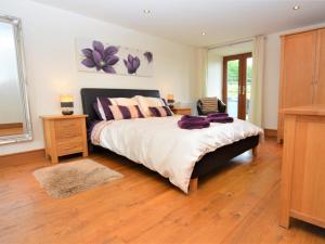 ein Schlafzimmer mit einem großen Bett und Holzboden in der Unterkunft 4 Bed in Kidwelly CWRTY in Kidwelly