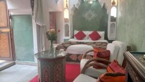 1 dormitorio con 2 camas, mesa y sillas en Riad Maizie, en Marrakech