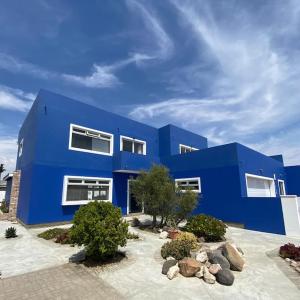 un edificio azul con rocas delante de él en 3 BDR Villa , unique in Swakopmund en Swakopmund