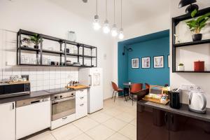 una cocina con armarios blancos y una pared azul en Maverick Hostel & Ensuites, en Budapest