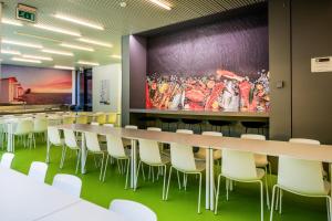 een vergaderzaal met een lange tafel en witte stoelen bij De Ploate Hostel in Oostende