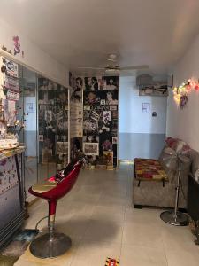 un salon avec une chaise rouge et des affiches murales dans l'établissement Hostal Flamenco Camaron, à Malaga
