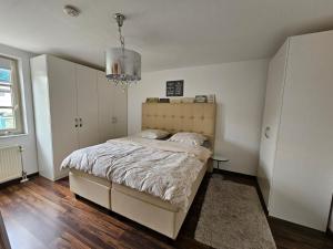 1 dormitorio con cama y lámpara de araña en Übernachten Sie im wunderschönen Weiden, en Colonia