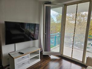 a living room with a flat screen tv and a balcony at Übernachten Sie im wunderschönen Weiden in Cologne
