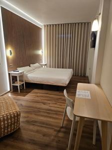 Habitación de hotel con cama, mesa y sillas en Hotel Villasegura en Molina de Segura