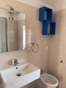 un bagno con lavandino, WC e specchio di Villa Vieste a Vieste Altre 28 foto