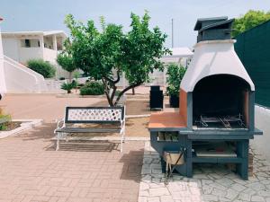 una griglia all'aperto con una panca accanto a un albero di Villa Vieste a Vieste