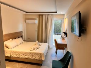 a bedroom with a bed and a desk and a television at San Remo Hotel in Larnaka