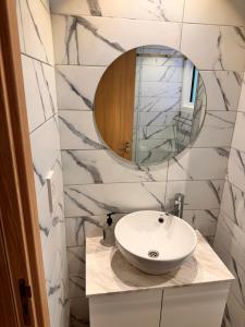 une salle de bain avec un lavabo et un miroir dans l'établissement San Remo Hotel, à Larnaka