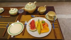 a table with a plate of fruit on a table at Margaret House in Mirissa