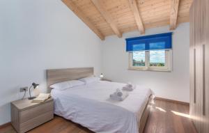 a bedroom with a bed with white sheets and a window at Villa Lory in Vabriga