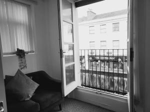 a room with a chair and a window with a view at High Street, 2 bed, newly refurb in Leamington Spa