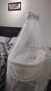una cesta blanca con una red junto a la cama en Loft lindo, acochegante e reservado en Boa Vista