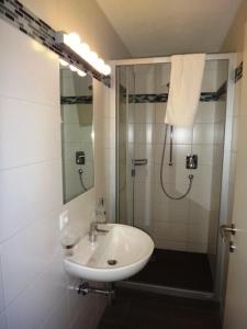 a white bathroom with a shower and a sink at Chalet Alber in Sankt Anton am Arlberg